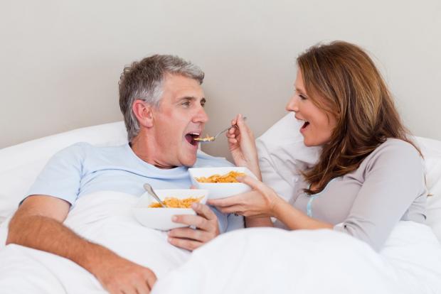 жена кормит мужа в постеле