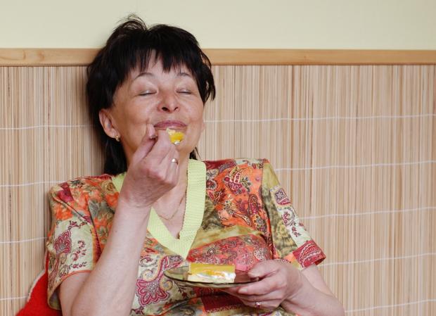 зрелая женщина ест торт