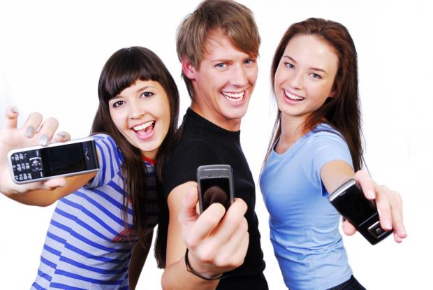 подростки с мобильными телефонами