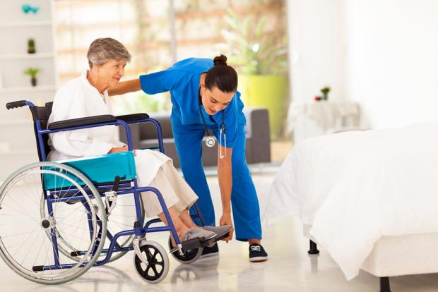 женщина в инвалидной коляске и медсестра