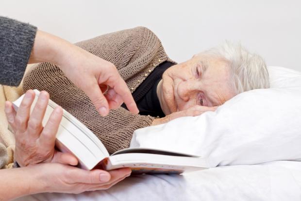пожилой женщине читают книгу
