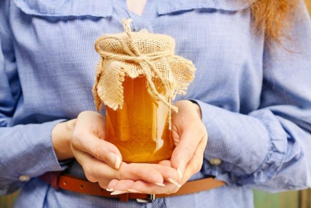 женщина держит в руках баночку с медом
