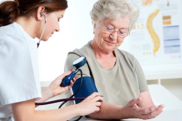врач измеряет пожилой женщине артериальное давление
