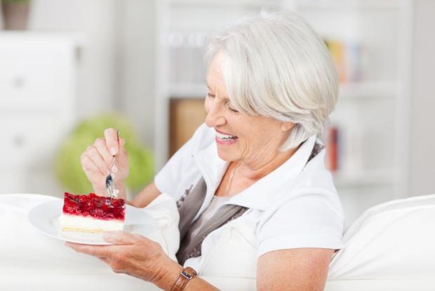 зрелая женщина кушает торт