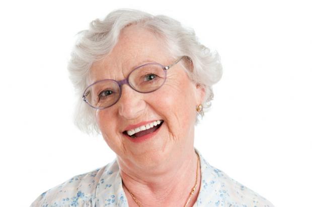 Happy smiling senior lady looking at camera with her glasses isolated on white background