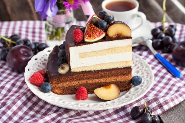 Piece of chocolate layer cake with cream and fresh fruit
