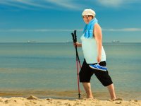 ru.depositphotos.com/Voyagerix: женщина занимается скандинавской ходьбой на пляже